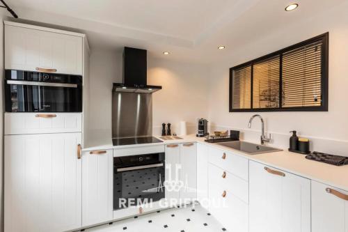 une cuisine avec des armoires blanches et un évier dans l'établissement La Petite Source - Downtown Honfleur - 2P, à Honfleur