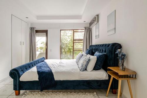 a bedroom with a blue bed and a window at 3bed luxury apartment sandton city in Johannesburg