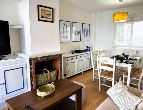 a living room with a fireplace and a table at Casa Mimbre ERENE032 in Cartaya