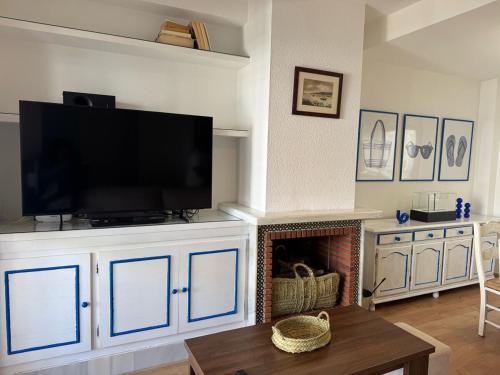 a living room with a television and a fireplace at Casa Mimbre ERENE032 in Cartaya
