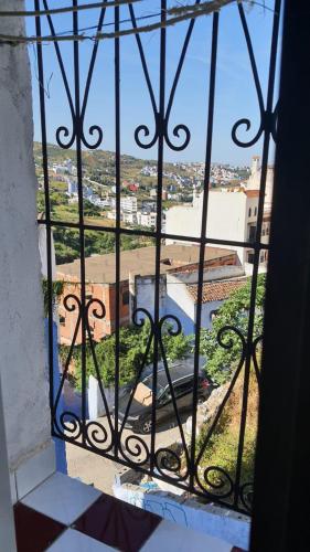 an iron window with a view of a city at Hostel ALINE in Chefchaouene