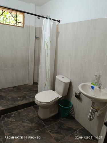 a bathroom with a toilet and a sink at Finca Arcanos Celeste in Barbosa