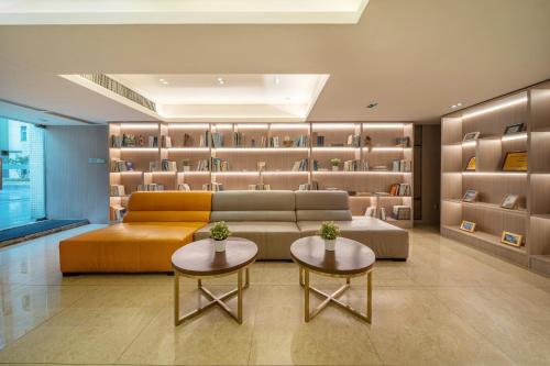a living room with a couch and two tables and shelves at Foshan Poltton International Serviced Apartment-Canton fair free shuttle bus in Foshan