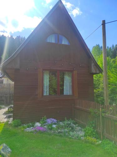 a wooden house with a window and a fence at Chata pre hostí s ohniskom in Spišská Nová Ves