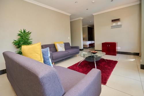 a living room with a purple couch and a glass table at Tamboti Guest Lodge in Pretoria