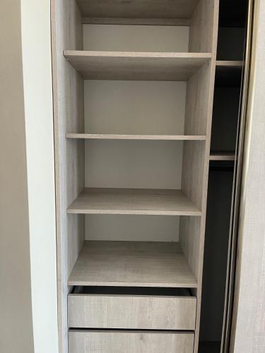 a wooden closet with empty shelves in a room at Apartment hotel in Yerevan in Merdzavan