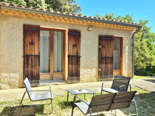un grupo de sillas y una mesa frente a una casa en Maison indépendante avec Jardin, Studio de 26m2 tout équipé avec Climatisation réversible, en Rochegude
