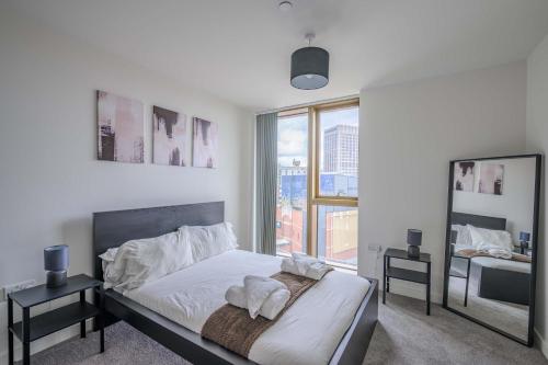 a bedroom with a bed and a large window at Stunning Central Birmingham1 Bedroom Apartment in Birmingham
