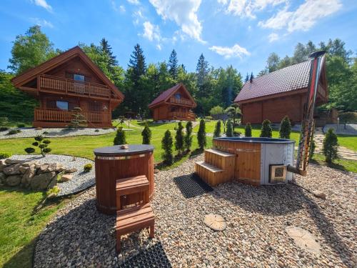 a backyard with a barbecue and a log cabin at Górskie Wytchnienie Domki Karkonosze in Piechowice