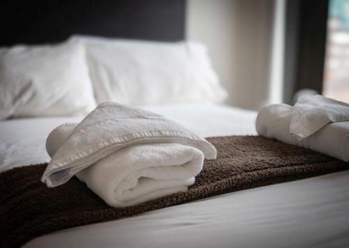 a pile of towels sitting on top of a bed at Stunning Central Birmingham1 Bedroom Apartment in Birmingham