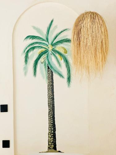 a painting of a palm tree on a wall at Tulia House Lamu in Lamu