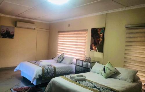 a room with two beds and a window at C-rane guesthouse in Phalaborwa