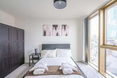 a bedroom with a bed and a large window at Stunning Central Birmingham1 Bedroom Apartment in Birmingham