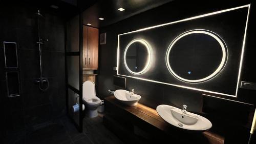 a bathroom with two sinks and a mirror and a toilet at Ying Yang House Catangnan in General Luna