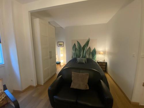 un salon avec un canapé en cuir noir dans l'établissement Joli et agréable studio, à Bordeaux