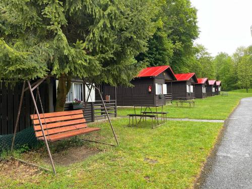 a park with a bench and some camp huts at ATC Kemp Kajlovec in Hradec nad Moravici