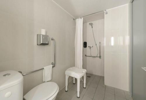 a white bathroom with a toilet and a shower at B&B HOTEL Alencon Nord in Alençon