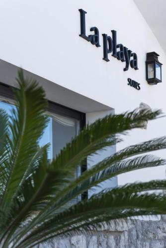 a palm tree in front of a building at La Playa Suites Suances in Suances