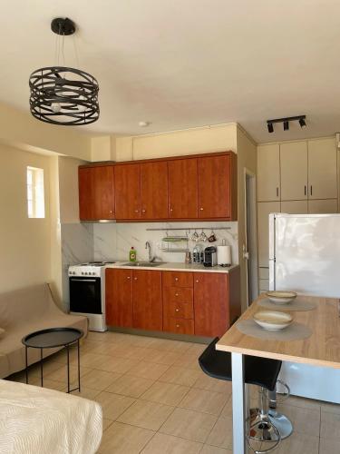 a kitchen with wooden cabinets and a white refrigerator at Cozy apartment of Chalkida in Chalkida