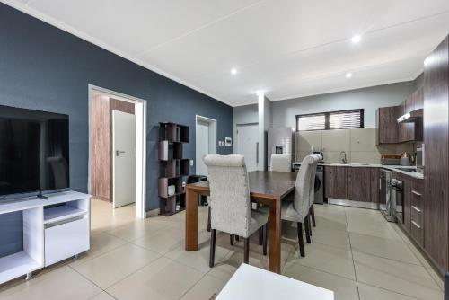 a kitchen and dining room with a table and chairs at The Odyssey Lifestyle Complex Morningside - 2 BR in Johannesburg