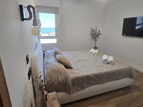 a bedroom with a bed with two pillows and a window at Intercomercio Feja Jupiter in Benalmádena