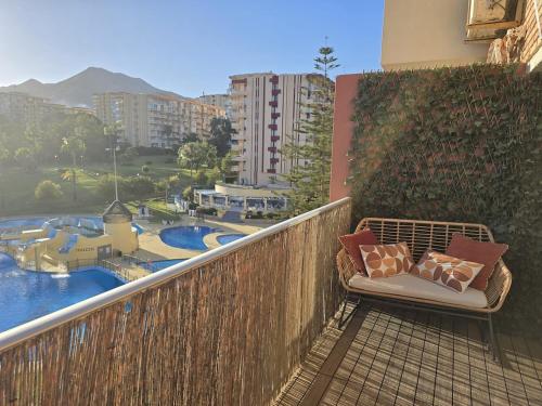 a chair on a balcony with a view of a resort at Intercomercio Feja Jupiter in Benalmádena