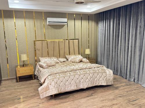 a bedroom with a large bed and two night stands at Golden Sand Modern 1 BHK Luxury Apartment in Rawalpindi