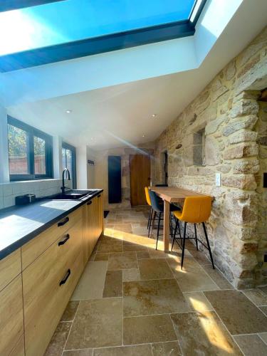 - une cuisine avec une table et un mur en pierre dans l'établissement Charmante Maison Rustique, à Piriac-sur-Mer