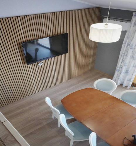 a dining room with a table and a tv on a wall at Kolyada Hotel in Odesa