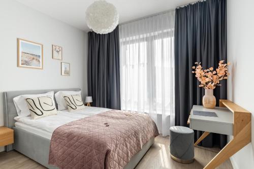 a bedroom with a bed and a large window at Gdańsk Old Town Apartments & Studios by Lion Apartments in Gdańsk