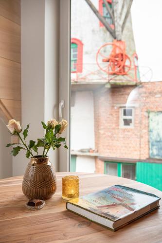 a book and a vase with flowers on a table at B&B 't Molenerf in Wingene