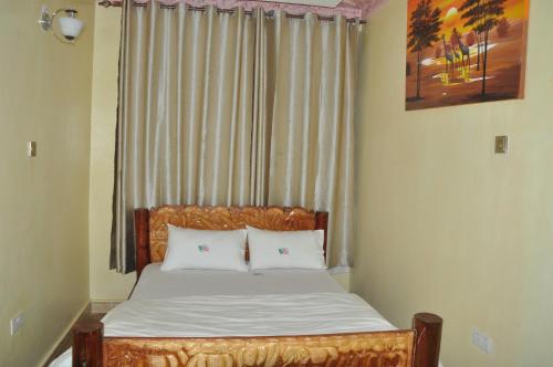 a bed with two white pillows in a bedroom at Trinity Resort Hotel & Spa in Kampala