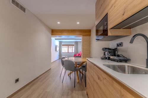 a kitchen with a sink and a dining table at Hotel La Milagrosa in Alicante