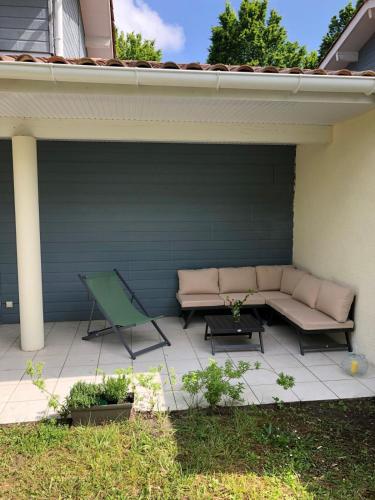 un patio avec un canapé, une table et une chaise dans l'établissement Ocean house, à Seignosse