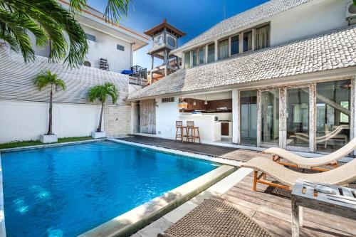 ein Swimmingpool vor einem Haus in der Unterkunft Villa Oberoi in Seminyak