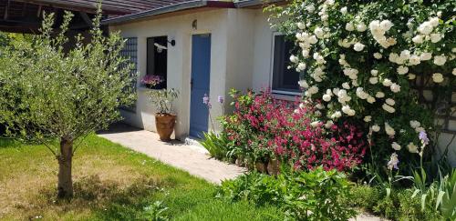 a house with a blue door and some flowers at Studio Carpe Diem proche Fontainebleau in Thomery