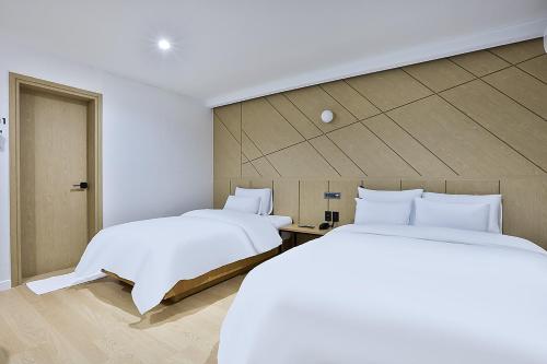 two beds sitting next to each other in a room at Brown Dot Gumi Okgye in Gumi