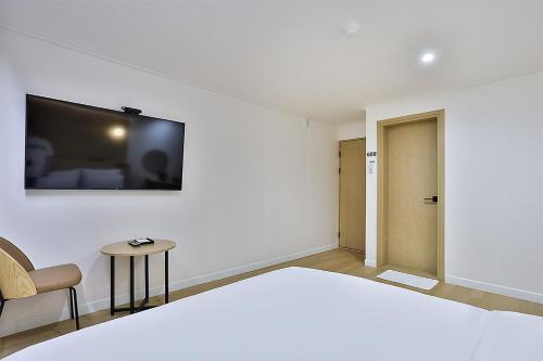 a bedroom with a bed and a tv on a wall at Brown Dot Gumi Okgye in Gumi