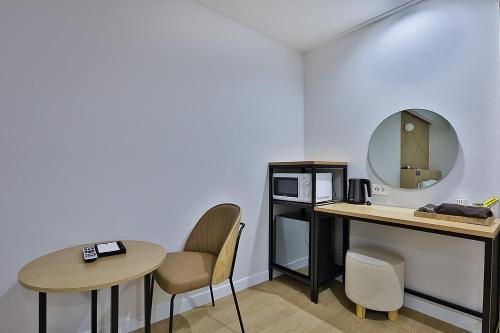 a room with a table and chairs and a mirror at Brown Dot Gumi Okgye in Gumi