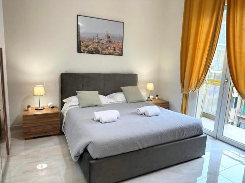 una camera da letto con un letto con due asciugamani sopra di NencioniHouse- Modern comfort close to city center a Firenze