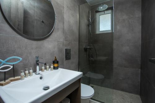a bathroom with a white sink and a shower at Matsi Suites in Faliraki