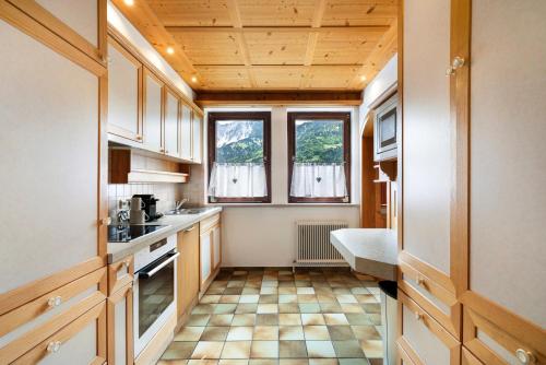 eine Küche mit Holzschränken und Fliesenboden in der Unterkunft Jordis in Vandans