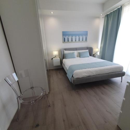 a bedroom with a large bed and a chair at Tonfano Waterfront Penthouse in Marina di Pietrasanta