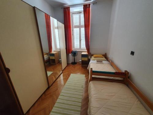 a small room with two beds and a mirror at Apartment Goga in Cres