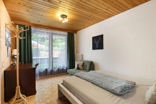 ein Schlafzimmer mit einem Bett und einem Stuhl und einem Fenster in der Unterkunft Jordis in Vandans