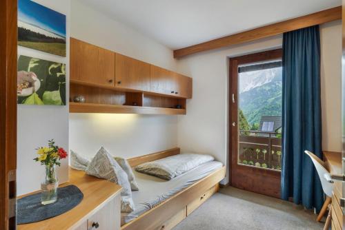 ein kleines Zimmer mit einem Bett und einem Fenster in der Unterkunft Jordis in Vandans
