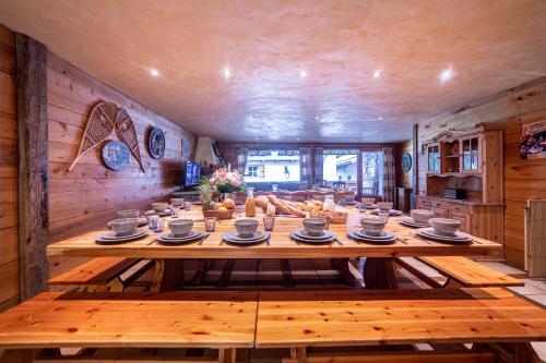 une salle à manger avec une grande table en bois dans la cuisine dans l'établissement Le Saint Bernard, à Champagny-en-Vanoise