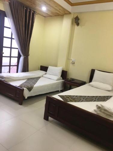 a bedroom with two beds and a window at Sa Pa Madame Huong Hotel in Sa Pa
