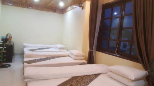 a room with four white pillows and a window at Sa Pa Madame Huong Hotel in Sa Pa