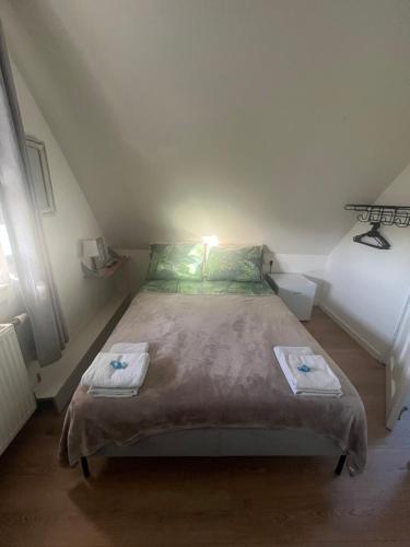 a bedroom with a bed with towels on it at B&B de Zandtaart in Egmond aan Zee